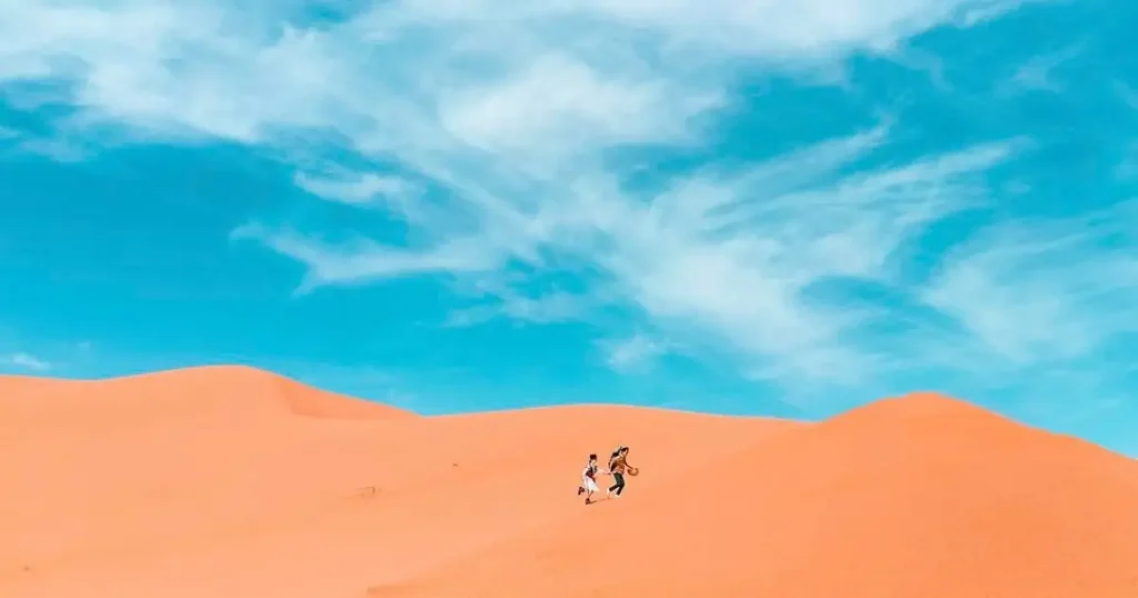 Photographer capturing Erg Chebbi sand dunes during golden hour in Merzouga