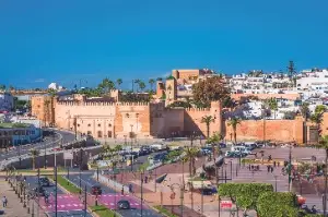 Wide angle view of Moroccan city traffic showing buses taxis delivery vans and pedestrians